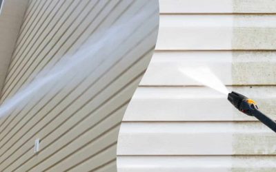 High-pressure washer cleaning beige siding on house for fresh look.